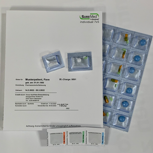 Eine individuell hergestellte Wochen-Medikamentenblisterung. Zu sehen sind ein beschrifteter Medikamentenplan, ein teilweise gefüllter Blisterstreifen mit sortierten Tabletten und Kapseln in verschiedenen Farben sowie zugehörige Etiketten. Das Bild veranschaulicht die professionelle Verblisterung und patientenindividuelle Arzneimittelversorgung durch die Kreuz Apotheke.